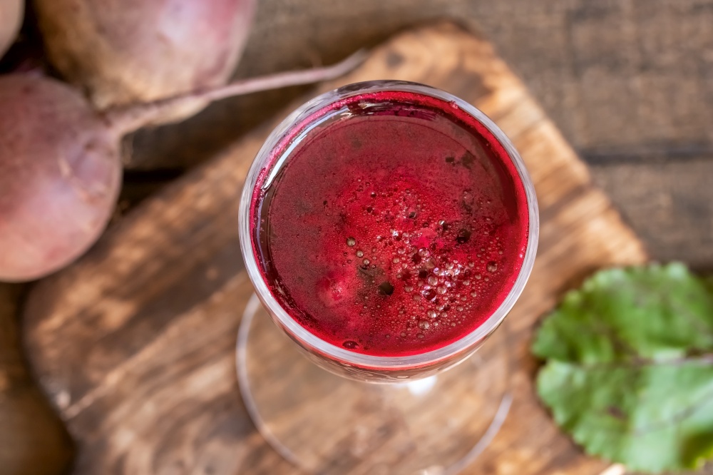 Red beet juice in a glass, top view