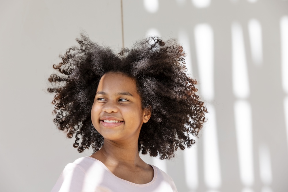 portrait of African American curly hair girl smiling with happiness and looking at camera.