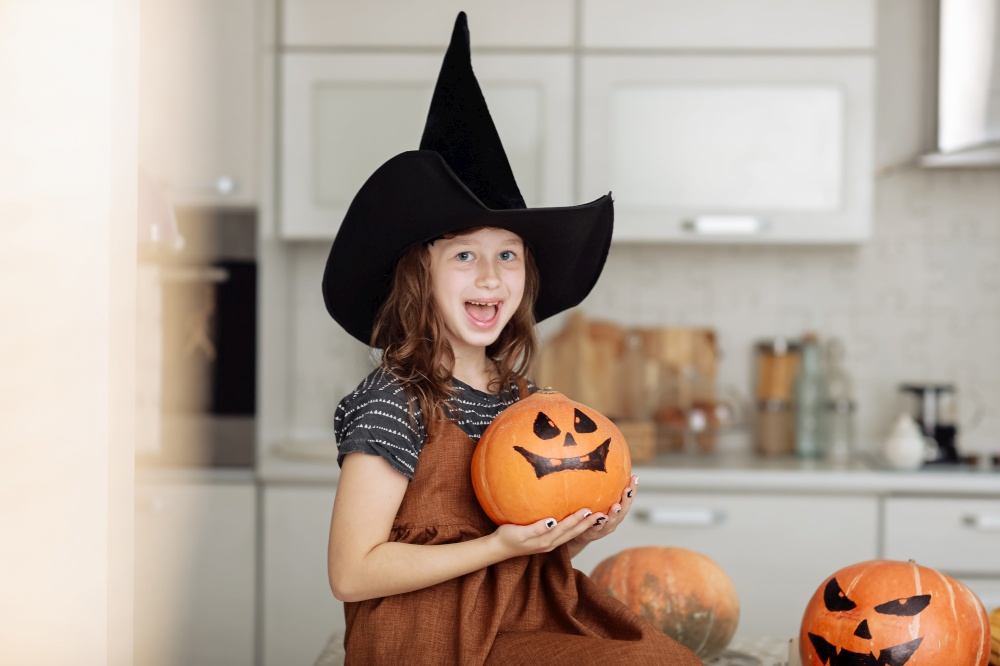 Happy halloween. Cute little girl in witch costume with carving pumpkin. Happy family preparing for Halloween. Happy halloween. Cute little girl in witch costume with carving pumpkin. Happy family preparing for Halloween.