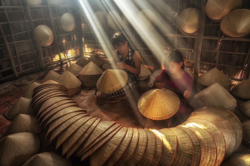 Two Vietnamese sisters craftsman making the traditional vietnam hat in the old traditional house in Ap Thoi Phuoc village, Hochiminh city, Vietnam, traditional artist concept