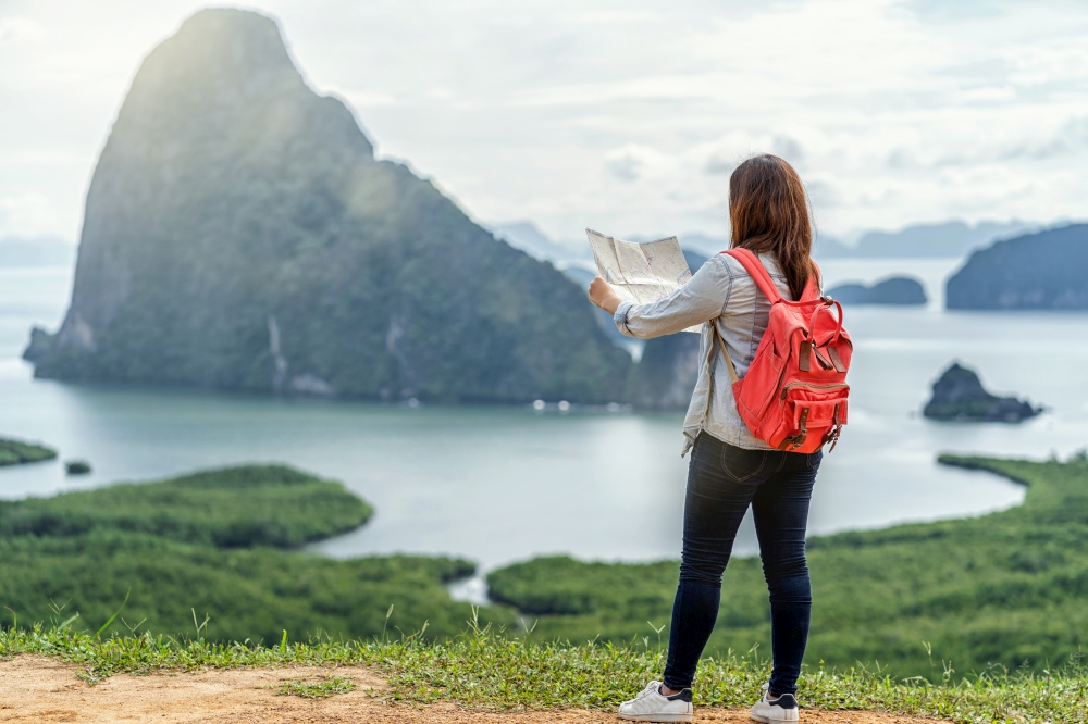 Back side of Asian woman traveler looking the map for travel with backpacker at Fantastic Landscape of samed nang chee view point, travel and holiday concept