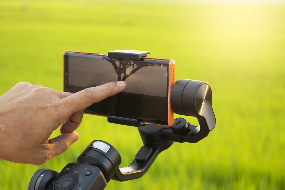 Male hand touching Smartphone attached to a gimbal