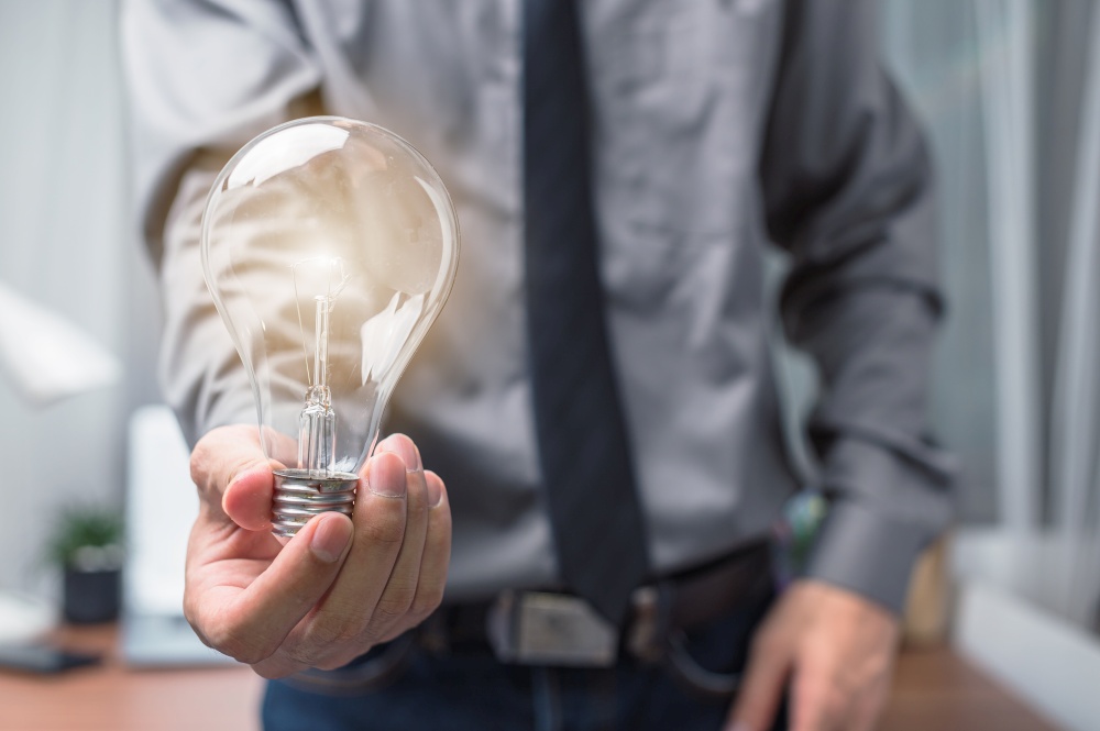 Businessman holding a light bulb and thinking of new ideas