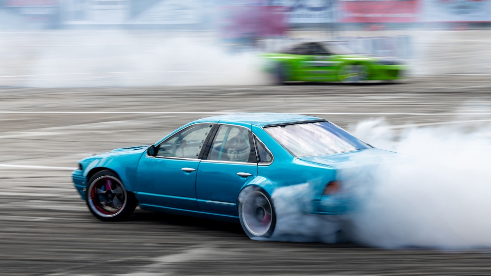 Blurred car drifting, Two car drifting battle on asphalt street road race track, Automobile and automotive drift car with smoke from burning tire on speed track.