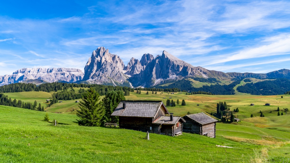Wooden chalets in Dolomites, Odle Mountains in the background of the Seceda Mountains, Trentino Alto Adige, South Tyrol, Italy, Europe.