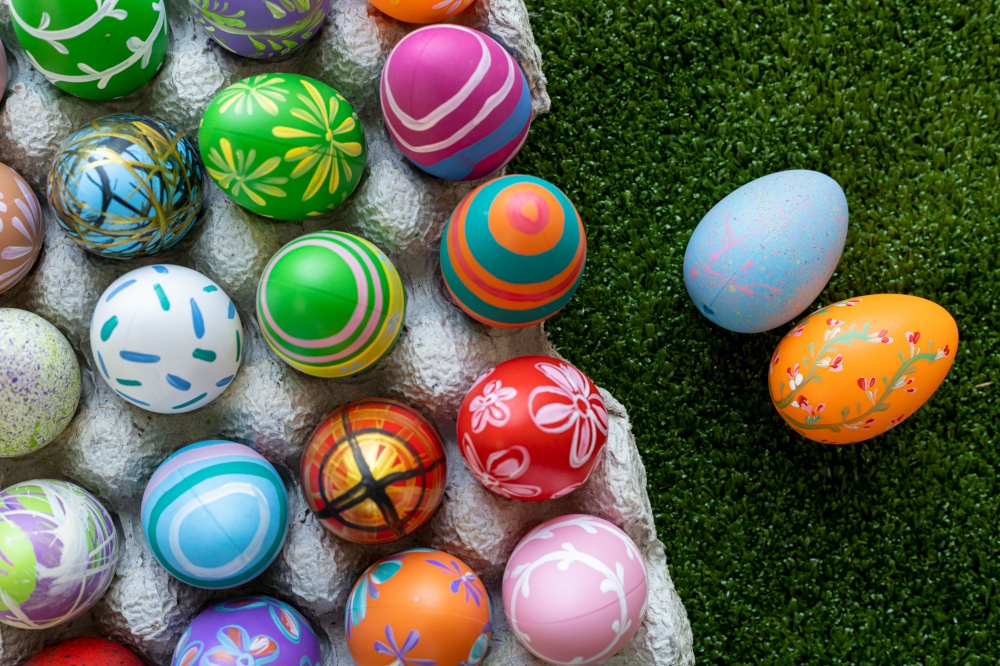 Easter holiday concept,Colorful Easter eggs in egg box,basket Easter eggs in green grass background with space.