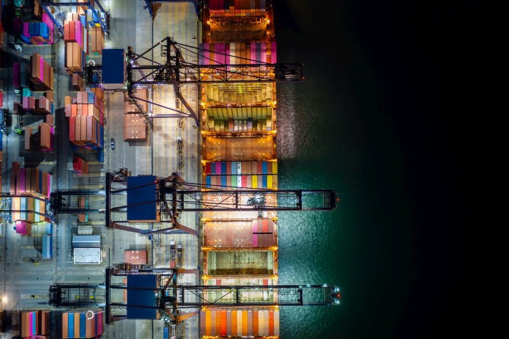 Night scene Container ship loading and unloading in deep sea port, Aerial view of business service and industry cargo logistic import and export freight transportation by container ship in open sea, Container loading Cargo freight ship.