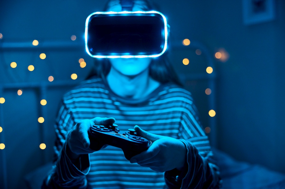 Teenage Girl Playing Video Game At Home In Bedroom Wearing Virtual Reality Headset At Night