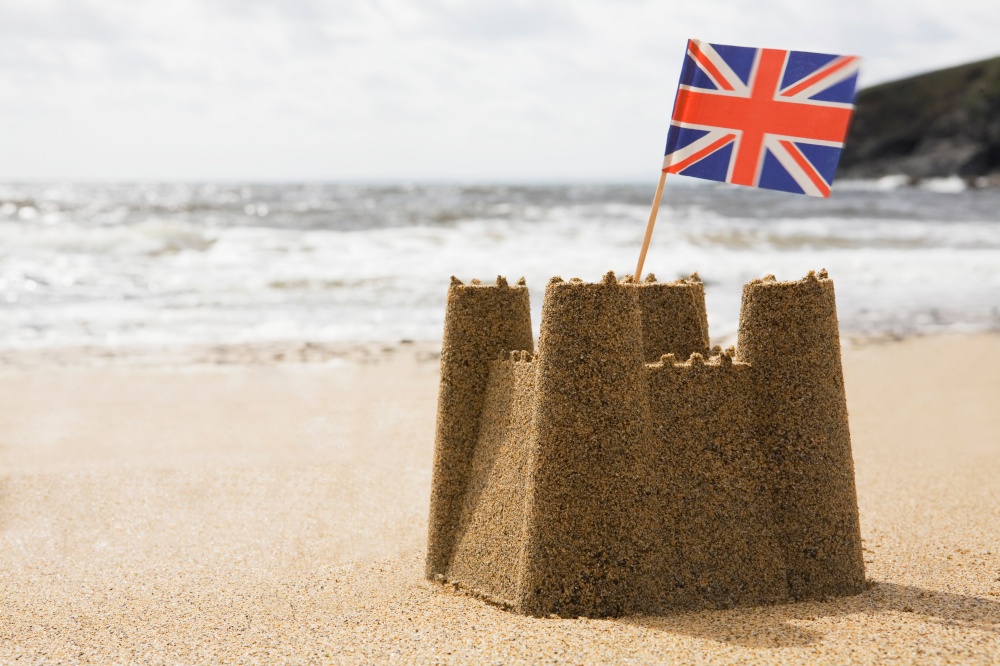 Sandcastle On Empty British Beach With UK Union Jack Flag Flying. Pohldu,Cornwall,UK