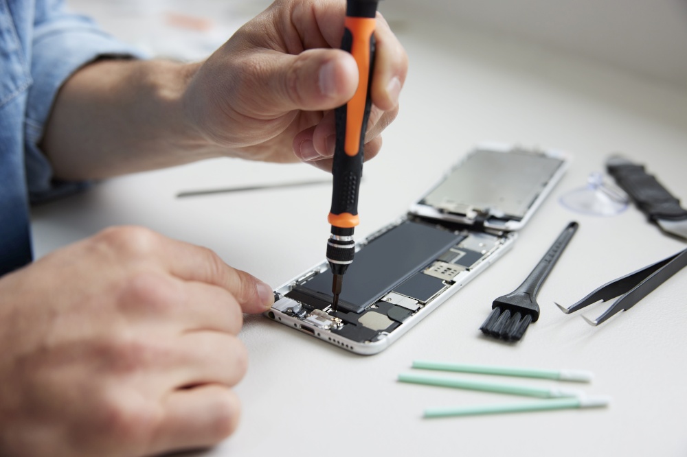Close Up Of Man Trying To Fix Mobile Phone Rather Than Buying New Product Sustainable Lifestyle