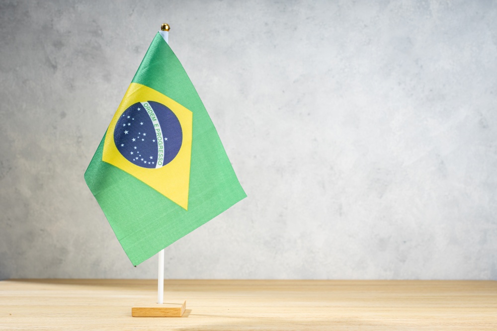 Brazil table flag on white textured wall. Copy space for text, designs or drawings