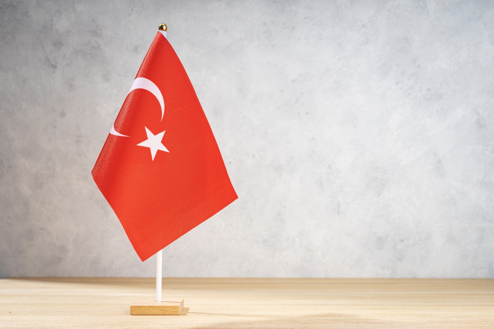 Turkey table flag on white textured wall. Copy space for text, designs or drawings