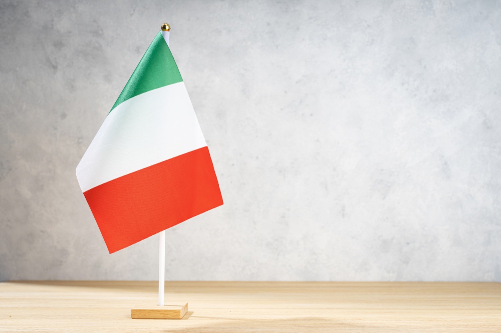 Italy table flag on white textured wall. Copy space for text, designs or drawings