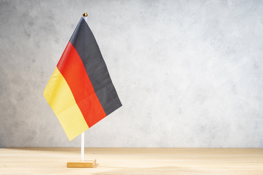 Germany table flag on white textured wall. Copy space for text, designs or drawings