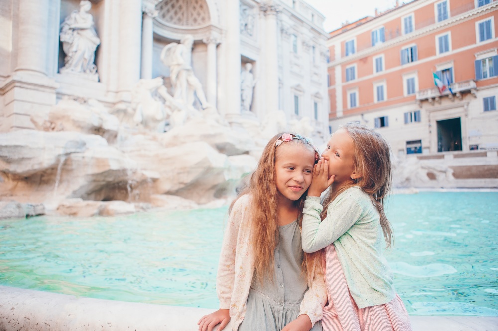 Adorable little girls near the Fountain of Trevi in Rome. Happy kids enjoy their european vacation in Italy. Adorable little girls near the Fountain of Trevi in Rome.
