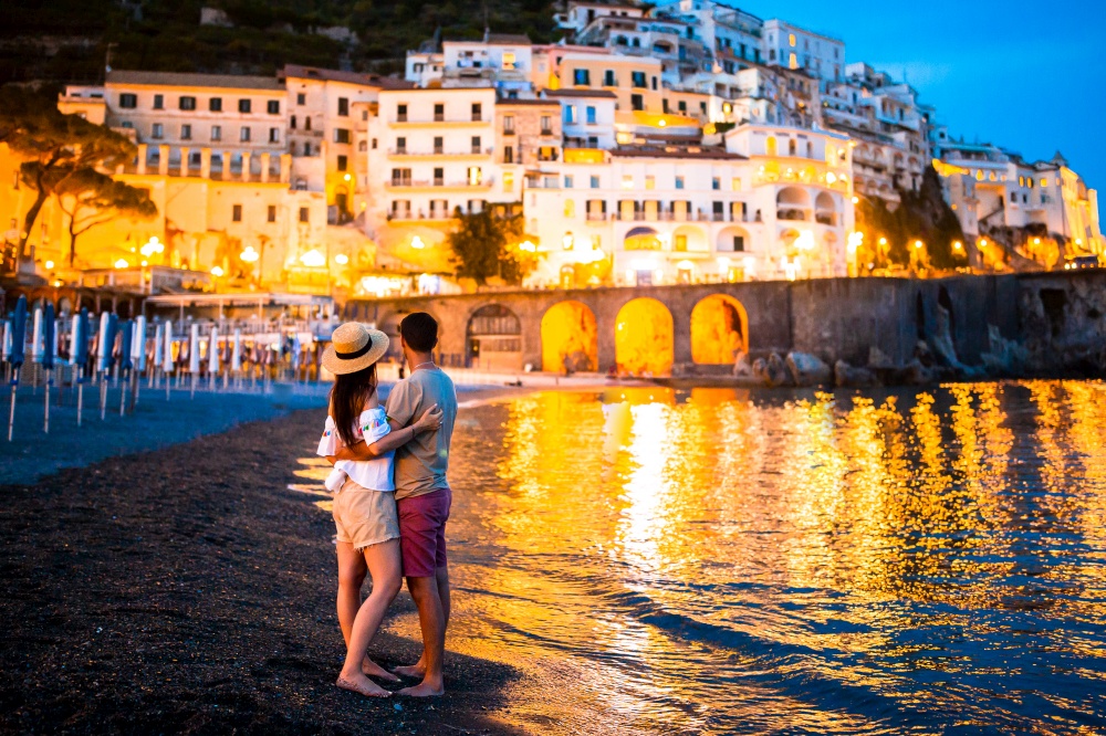 Beautiful couple in Amalfi town in the evening. Family on sunset in Amalfi town in Italy