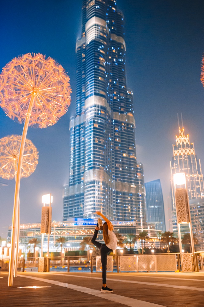 Adorable little girl in night Dubai on vacation. Happy girl walking in Dubai with skyscraper in the background.