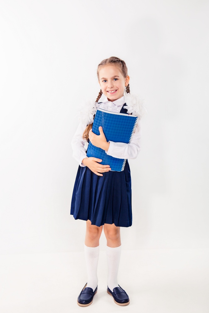 Cute schoolgirl with notebooks and books on a white background. Satisfied students.. Cute schoolgirl with notebooks and books on a white background.