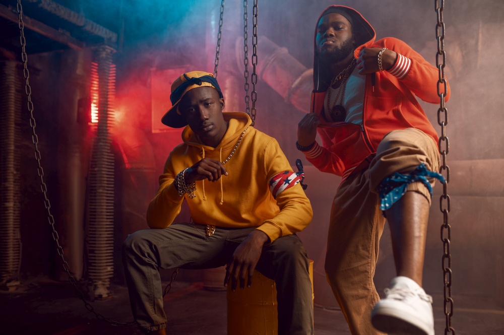 Two stylish rappers dancing in studio with cool underground decoration. Hip-hop performers, trendy rap singers, break-dancers. Two stylish rappers dancing in studio