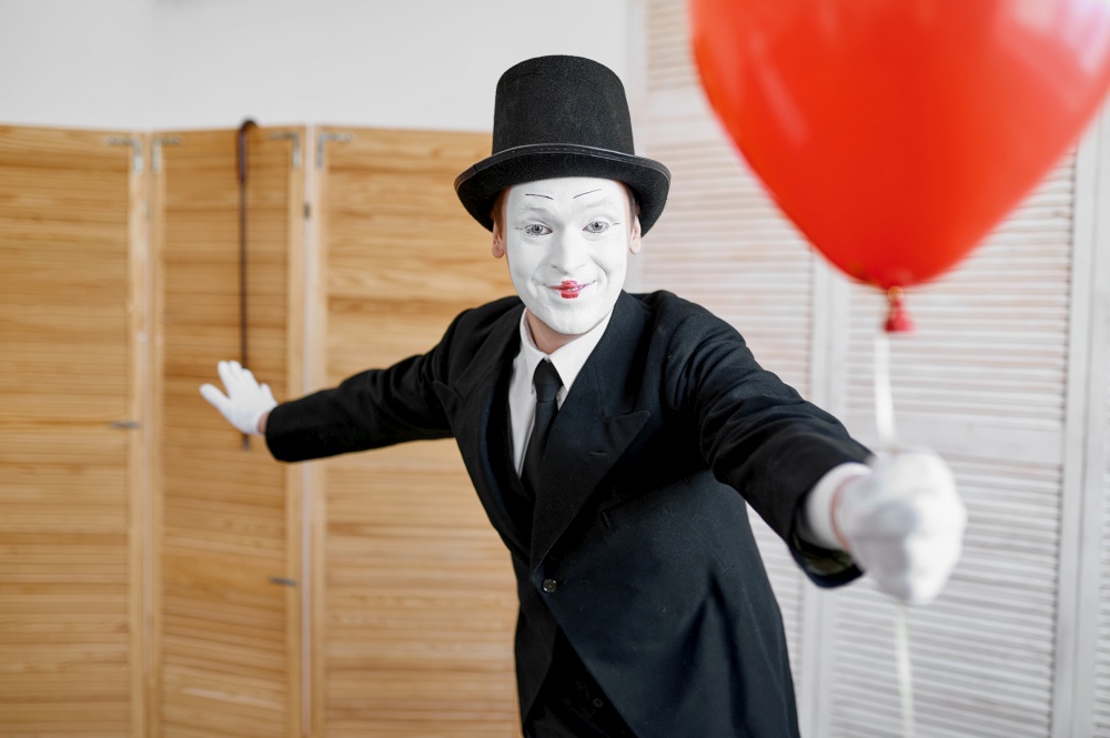 Mime artist with air balloon, comedy parody. Pantomime theater, comedian, positive emotion, humour performance, funny face mimic and grimace. Mime artist with air balloon, comedy parody