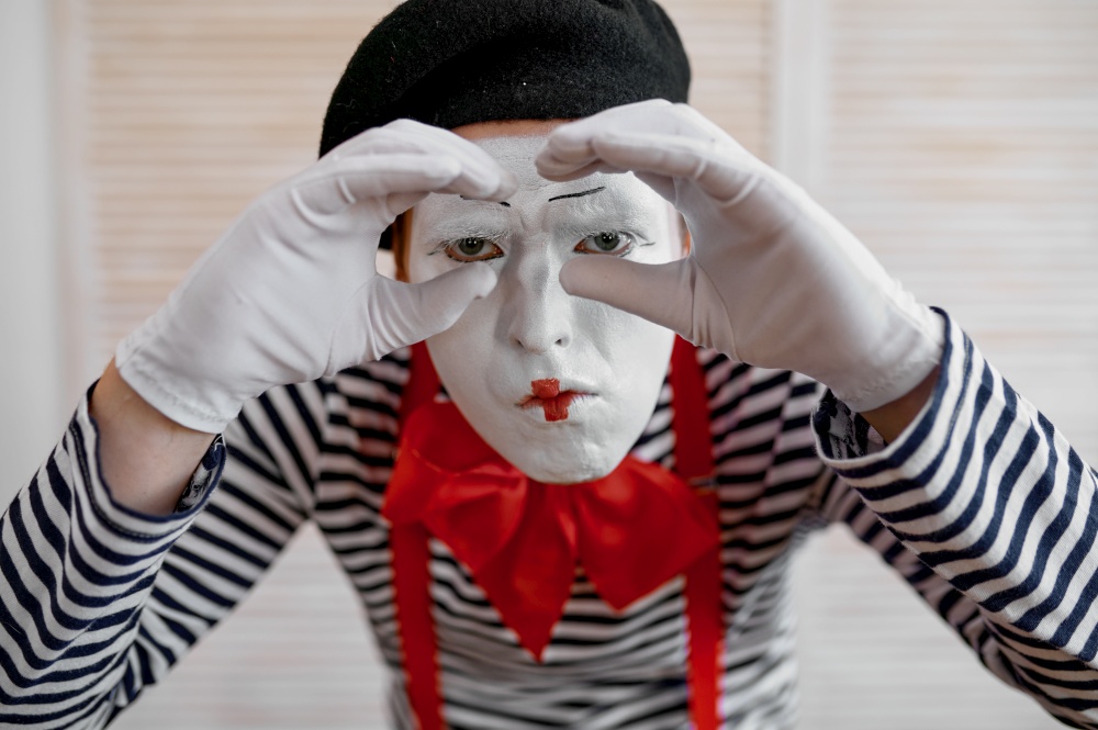 Mime artist, binoculars gesture, parody comedy. Pantomime theater, comedian, positive emotion, humour performance, funny face mimic and grimace. Mime artist, binoculars gesture, parody comedy