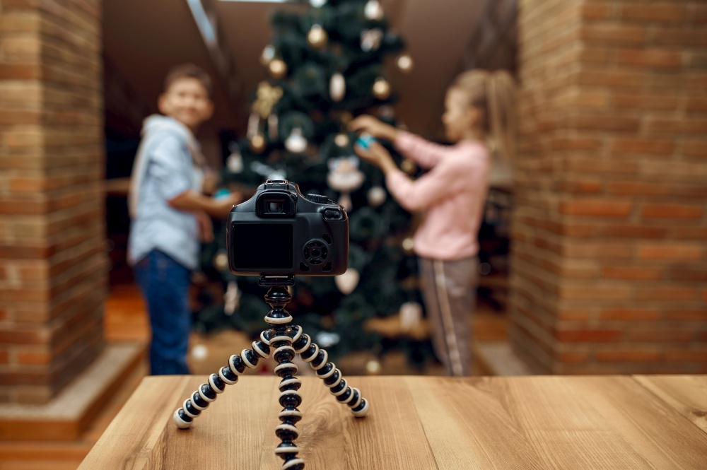 Children bloggers recording xmas blog on camera, vloggers. Kids blogging in home studio, social media for young audience, online internet broadcast. Children bloggers recording xmas blog, vloggers