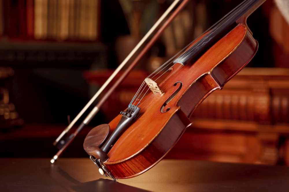 Violin in retro style and bow, closeup view, nobody. Classical string musical instrument, old viola, dark background. Violin in retro style and bow, closeup view