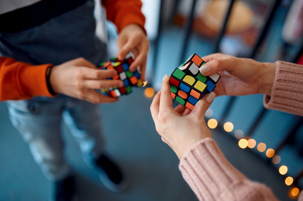 People play with puzzle cubes, intellectual rest. Toy for brain and logical mind training, creative game, solving of complex problems. People play with puzzle cubes, intellectual rest