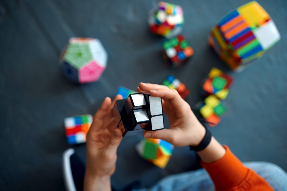Male child play with puzzle cubes. Toy for brain and logical mind training, creative game, solving of complex problems. Male child play with puzzle cubes