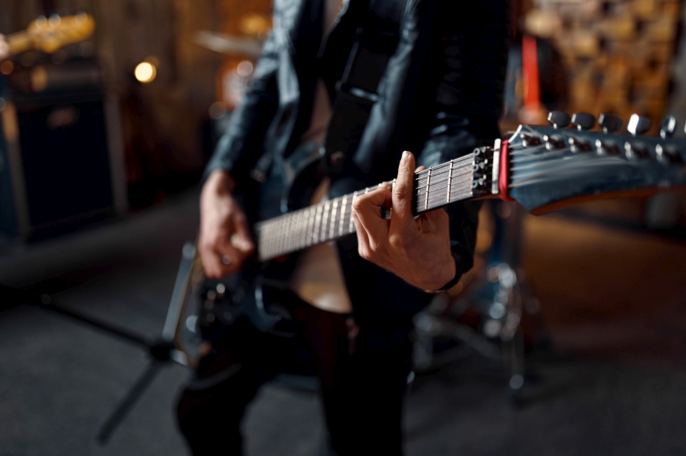 Brutal guitarist with electric guitar, music performing on stage. Rock band performance or repetition in garage, man with string musical instrument, live sound. Brutal guitarist with electric guitar on stage