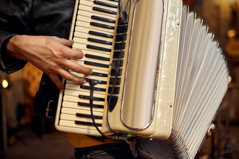 Two brutal musicians with accordion and electric guitar, music performing on stage. Rock band performance, concert repetition in garage, man with musical instrument. Two musicians with accordion and electric guitar