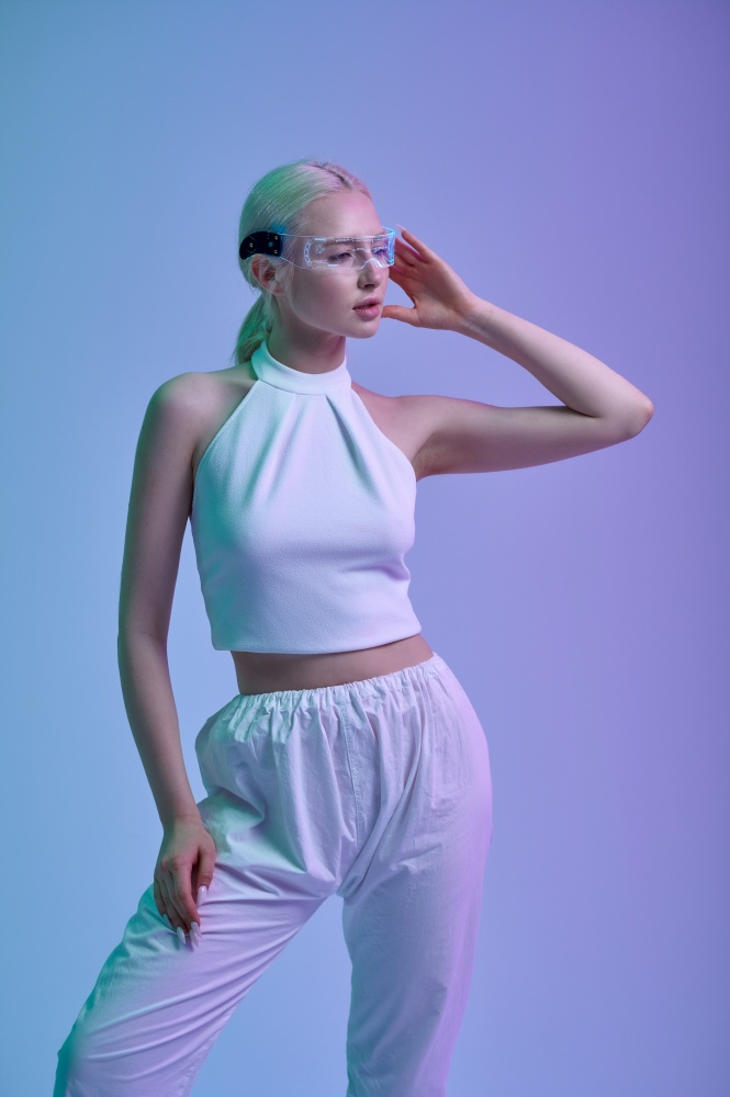 Attractive futuristic woman in white clothes and modern glasses, grey background. Sexy female person in virtual reality style, future technology, futurism concept. Attractive futuristic woman in modern glasses