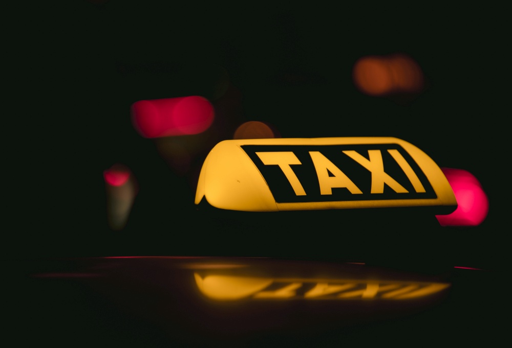 A closeup shot of the Taxi sign placed in a dark background. Closeup shot of the Taxi sign placed in a dark background