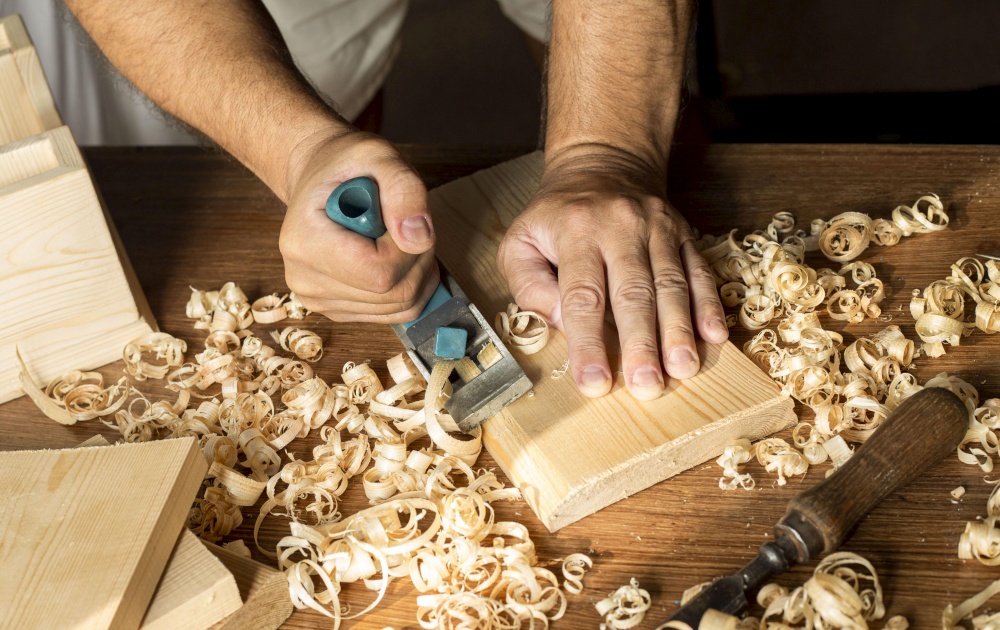 Carpenter working with small saw making sawdust