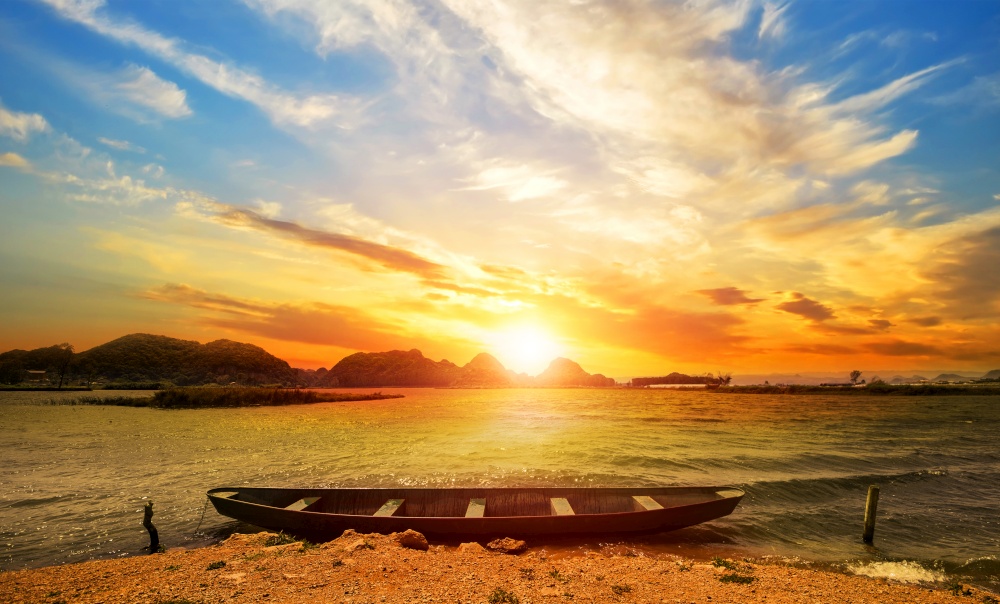 sunrise with boat on the beach