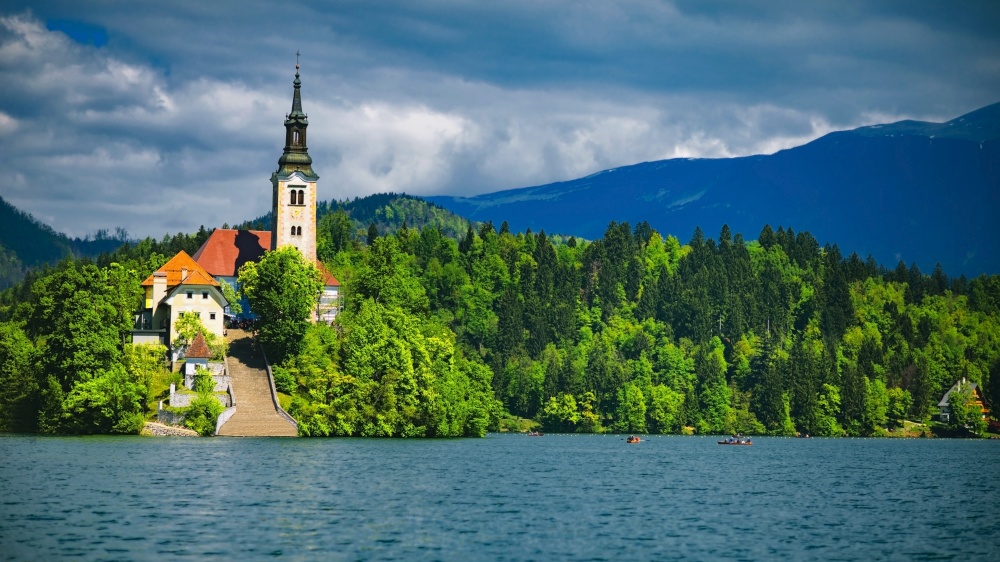 Bled Lake with church and mountains in background, cloudy sky