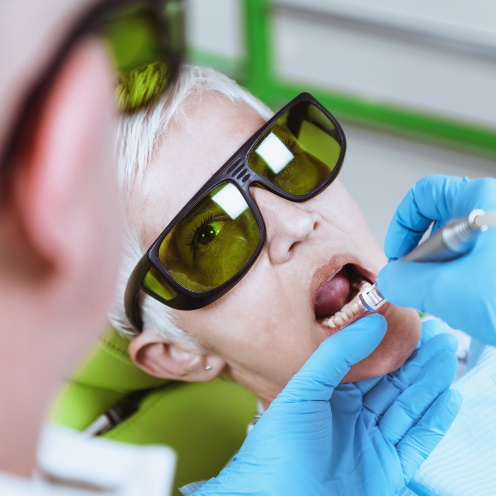 Laser Teeth Whitening. Portrait of a senior woman visiting dentist for teeth whitening in clinic. Senior Dental Care.