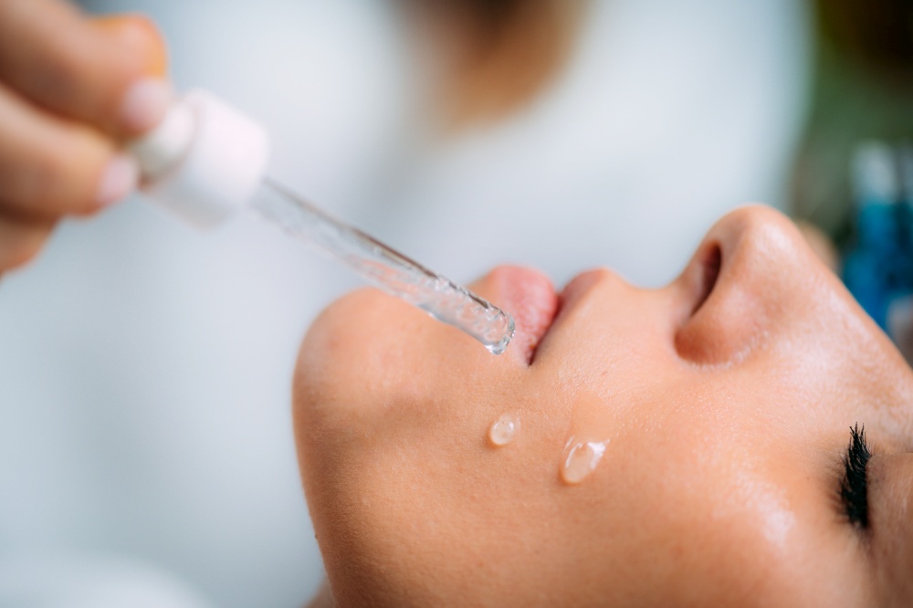Cosmetician Applying Hyaluronic Acid Serum on Woman&rsquo;s Face