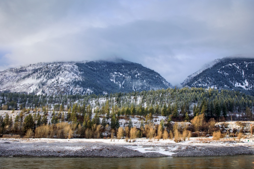 Scenic snow covered forests and mountains along Fraser River in Fraser Canyon