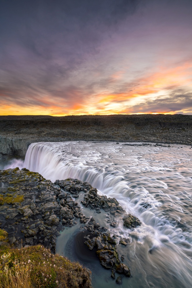 Detifoss waterfall with sunset in the background, Iceland
