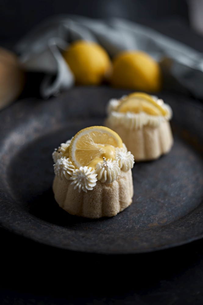 mini lemon bundt cakes topped with lemon.  lemon bundt cakes