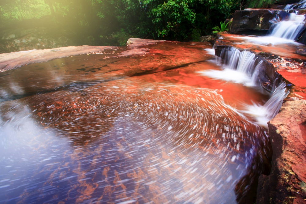 Pure streamlet falling on layers of sandstone pool, abstract stream with froth on surface of the pool. Long exposure. Zen meditation concept. Soft focus on surface of the pool.
