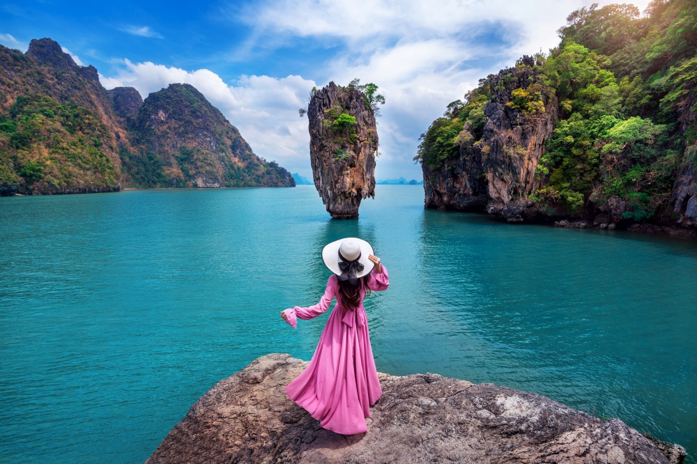 Beautiful girl standing on the rock at James Bond island in Phang nga, Thailand.