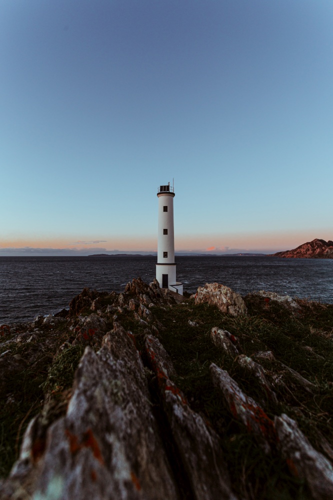 A lighthouse in the spanish coast during the witch hour on wide angle with copy space