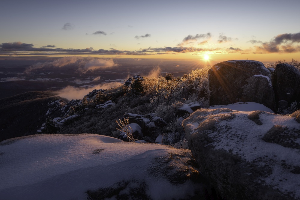 An absolute frigid and windy sunrise atop Old Rag Mountain looking across the icy rock scramble in Shenandoah National Park, Virginia.