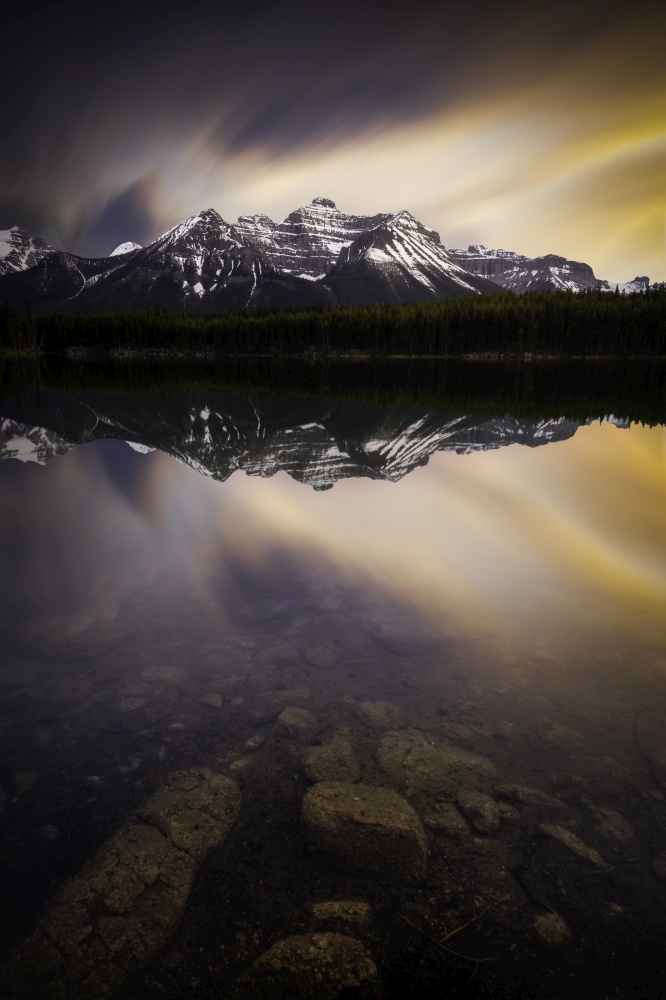 Intense sunset colors reflected in Herbert Lake alongside the Icefields Parkway of Banff National Park.