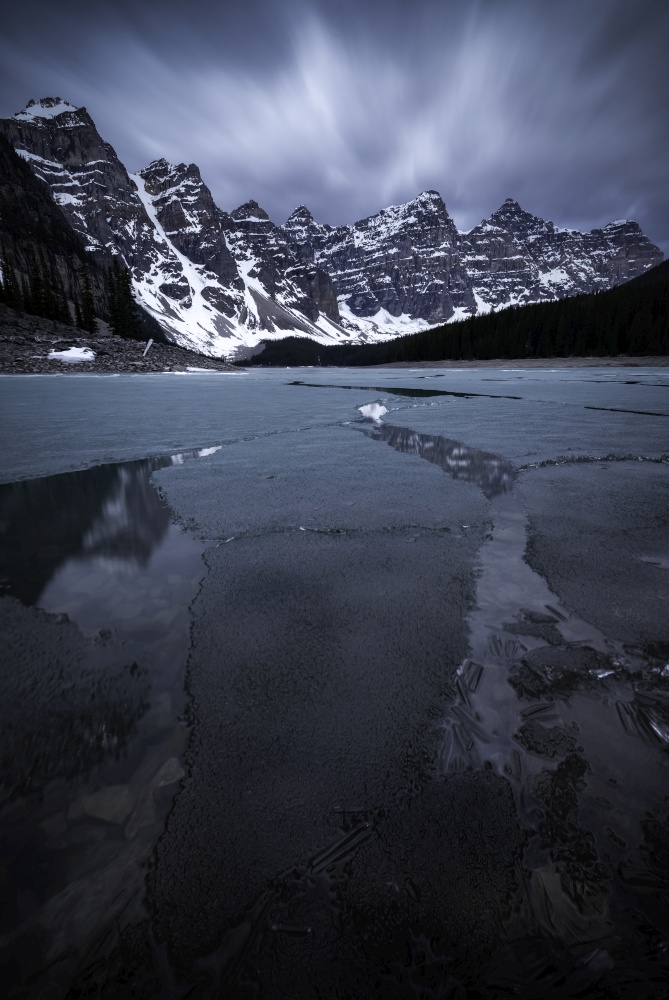 The last remaining ice breaks apart on Moraine Lake in early June at sunrise in the Canadian Rockies of Alberta, Canada.