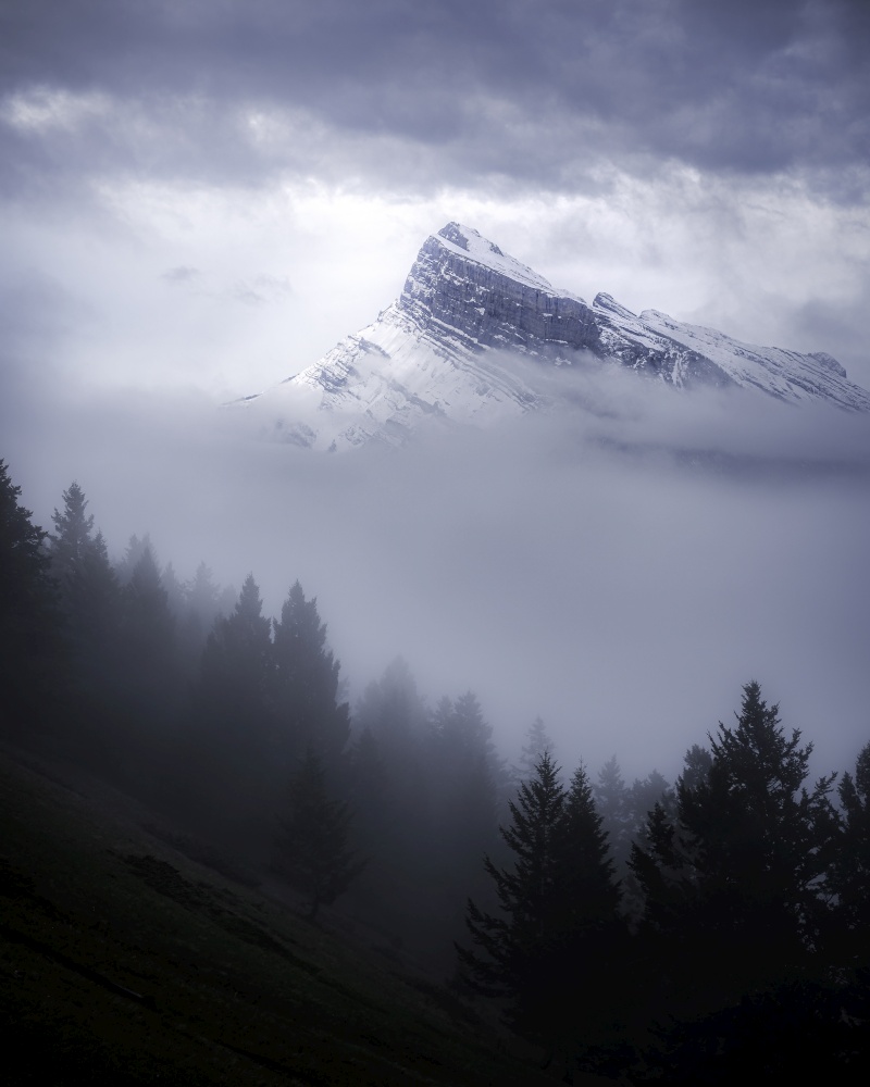Mount Rundle peers out from the fog and clouds on a Summer morning in Banff National Park