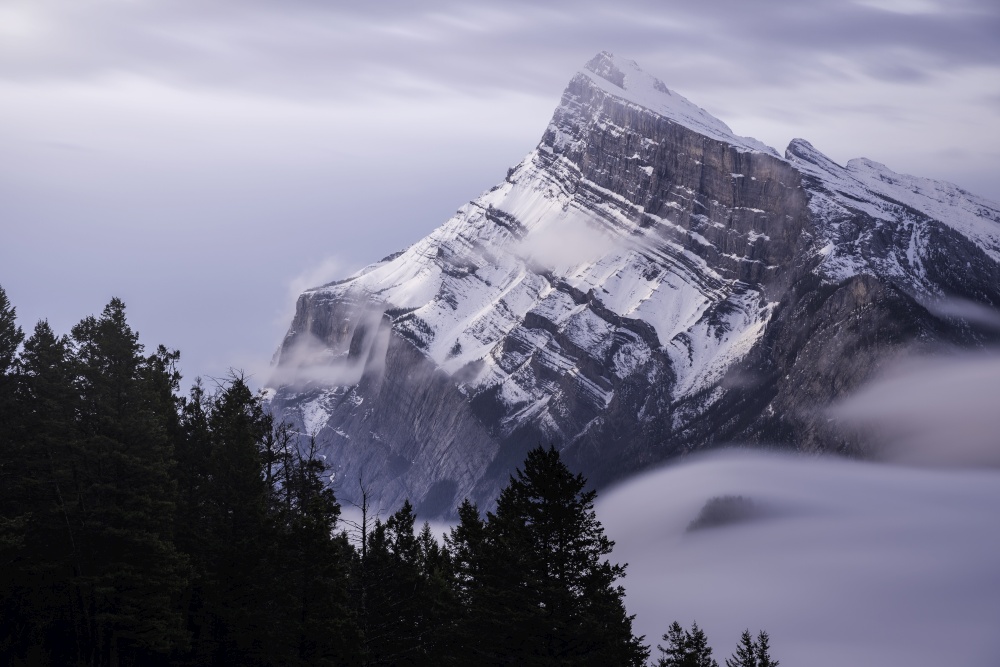 A long exposure of Mount Rundle as the clouds move and swirl around in the morning sky.