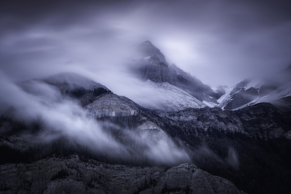 Swirling clouds around a mountain peak early in the morning in Jasper National Park.